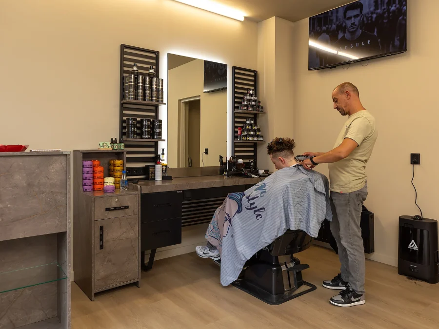 Een barbier knipt het haar van een klant
