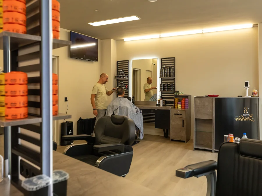 Haarproducten op de kaptafel, met een barbier aan het werk